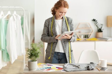 Moda tasarımcısı tablet üzerinde yeni taslak koleksiyonu tarıyor