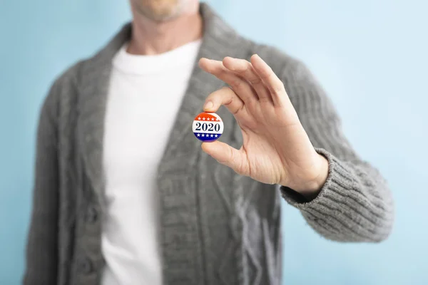 Unrecognizable american citizen holding voting pin with text