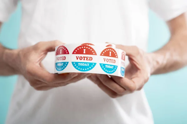 Man holding I vote today stickers roll with American flag — Stock Photo, Image