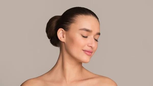 Young woman with hair bun and closed eyes — Stock Photo, Image
