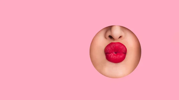 Γυναίκα δείχνει κόκκινα χείλη από ροζ χάρτινη τρύπα — Φωτογραφία Αρχείου