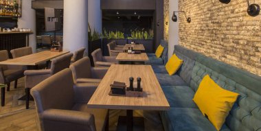 Koltukları ve ahşap masaları olan şirin bir restoran.