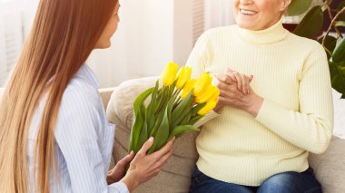 Kızınız büyük anneye bir buket lale sunuyor.