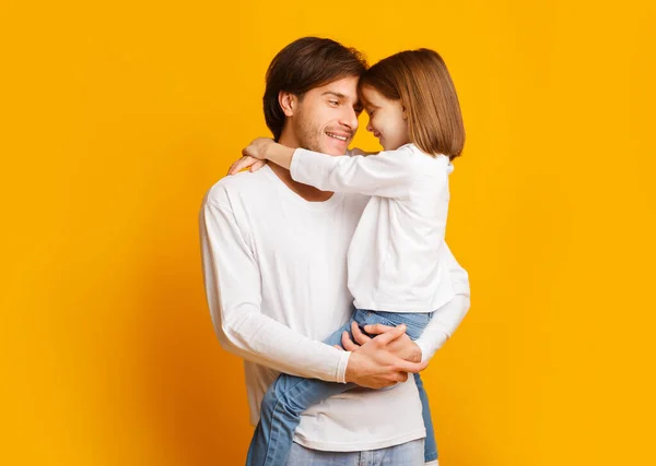 Отец и дочь связаны на жёлтом фоне — стоковое фото