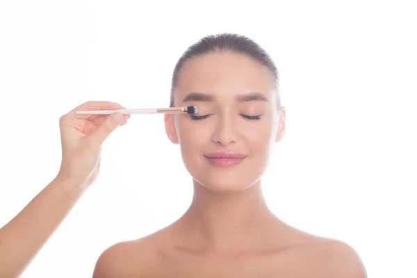 Makeup artist applying eyeshadow on female model face — Stock Photo, Image