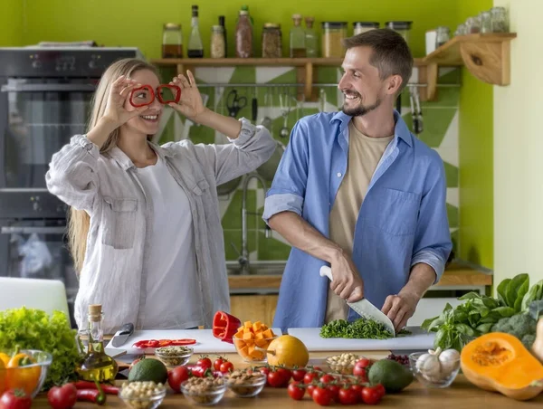 Roligt ungt par leker med grönsaker tillsammans — Stockfoto