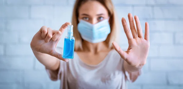 Остановить эпидемию. Женщина в маске держит антисептик — стоковое фото