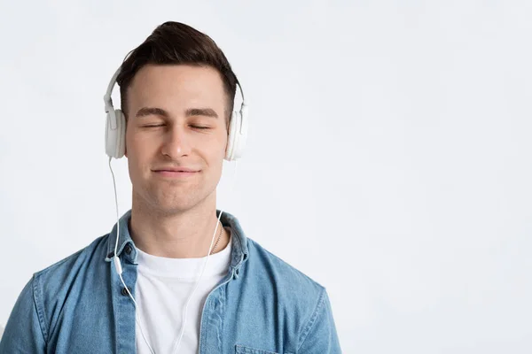 Homem olhos fechados, gosta de música em fones de ouvido — Fotografia de Stock