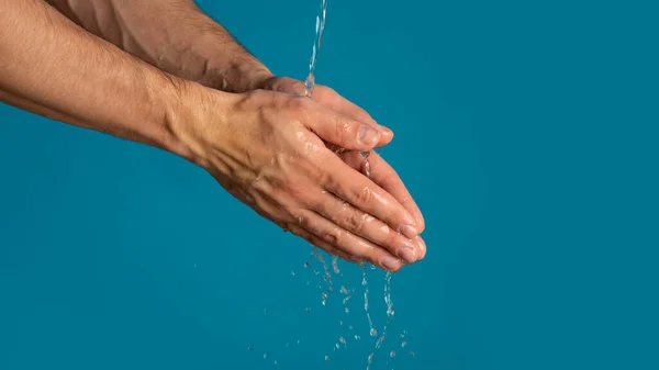 Hygiena během epidemie. Detailní záběr muže, jak myje ruce na modrém pozadí, kopíruje prostor. Panorama — Stock fotografie