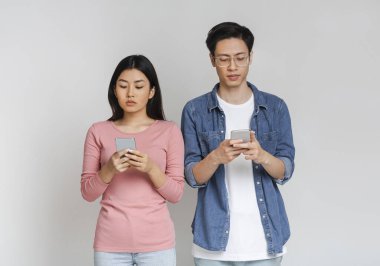 İzolasyon sırasında cep telefonu kullanan Asyalı çift