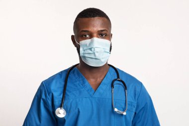 Yüzünde beyaz maske olan kendine güvenen siyah bir doktorun portresi.