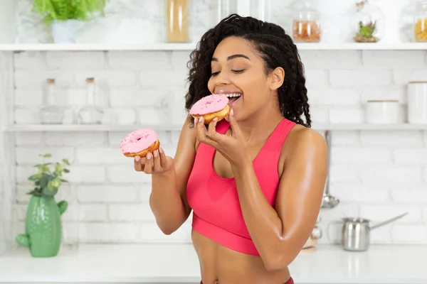 Feliz magro preto menina comer dois donuts — Fotografia de Stock
