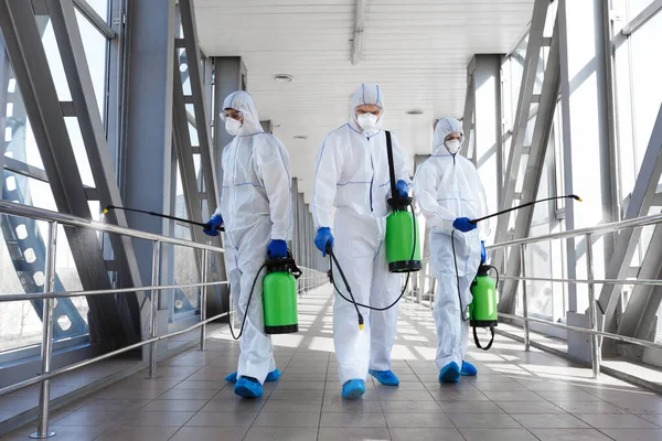 穿着防护服准备消毒的专业病毒学家小组 — 图库照片