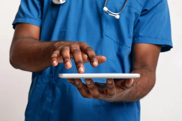 Primer plano del médico africano usando tableta digital —  Fotos de Stock