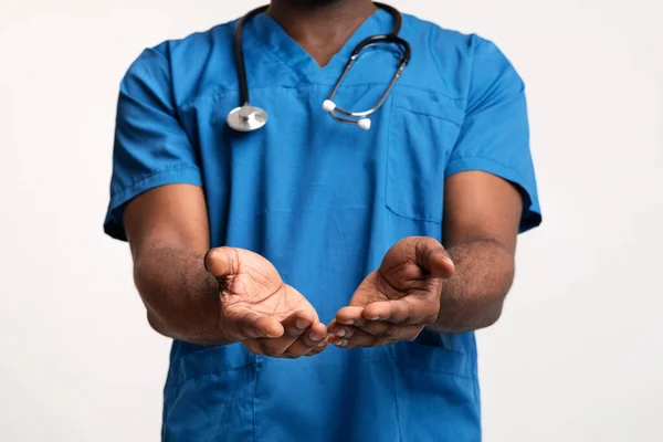 Médico preto de uniforme azul dando algo aos pacientes — Fotografia de Stock