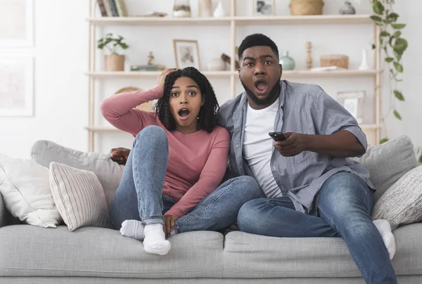 Noticias del Coronavirus. Impresionante pareja afroamericana viendo televisión con la boca abierta —  Fotos de Stock