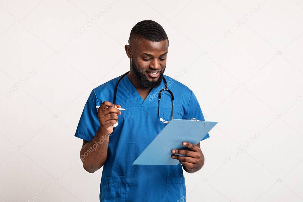 African doctor making check up, filling medical form