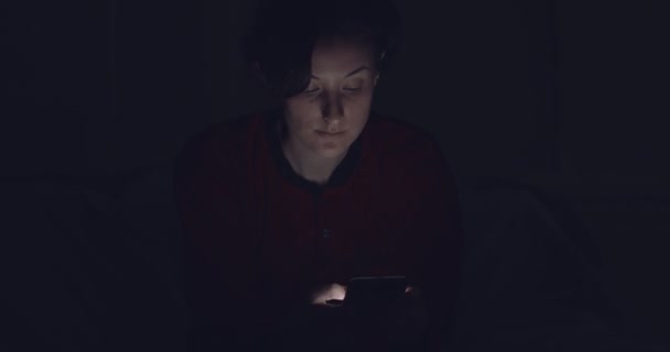 Mujer charlando con amigos en el teléfono celular en la oscuridad — Vídeos de Stock