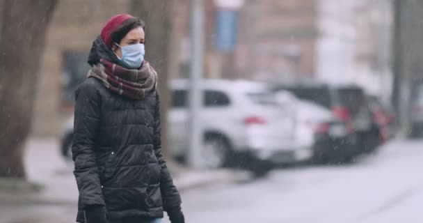 Mujer con máscara protectora cruzando la calle en la calle vacía de la ciudad — Vídeos de Stock