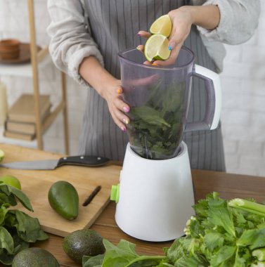 Kadın pesto yapmak için blender kullanıyor. Vejetaryen, temiz yemek.