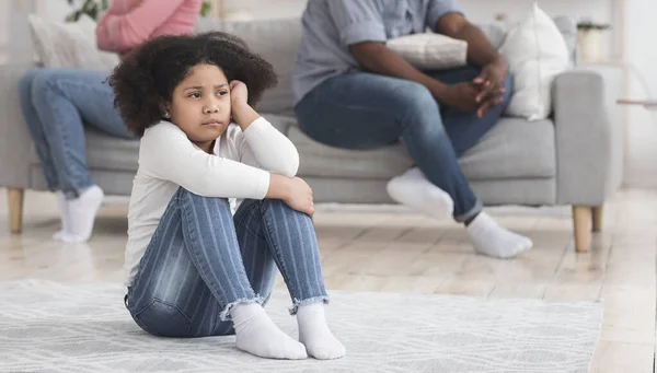 Overstuur klein meisje lijden aan ouders ruzies, zitten op de vloer alleen — Stockfoto