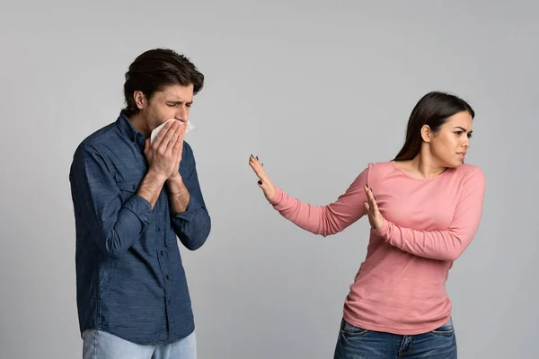 社会的距離。Young woman disgusted by sick boyfriend with runny nose — ストック写真