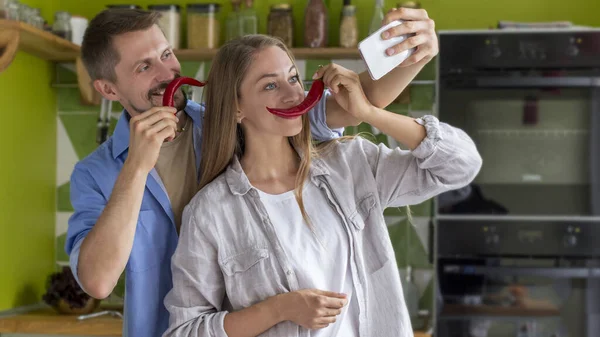 Jóvenes Pareja de veganos haciendo selfie con bigote de chile en la cocina — Foto de Stock