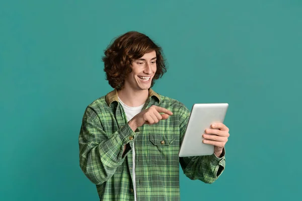 거리 통신. 태블릿 컴퓨터를 가리키며 컬러 배경으로 채팅하는 행복 한 10 대 남자 — 스톡 사진