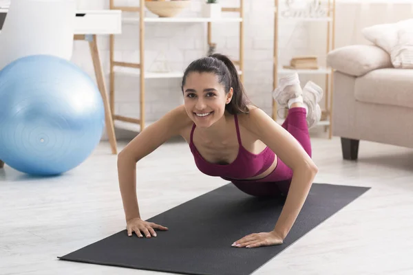 Antrenament acasă. Fericit latino fata face push up-uri pe yoga mat în interior — Fotografie, imagine de stoc