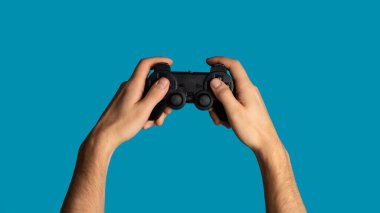 Evde kal. joystick 'i tutan genç adam, arka planda video oyunları oynayan, yakın plan. Panorama