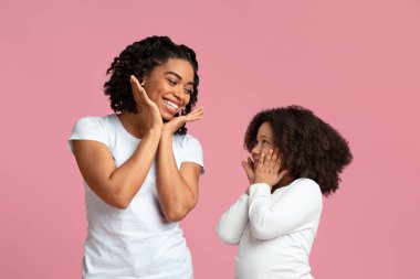 Küçük siyah kız annesiyle vakit geçirmekten zevk alıyor, hareketlerini tekrarlıyor.