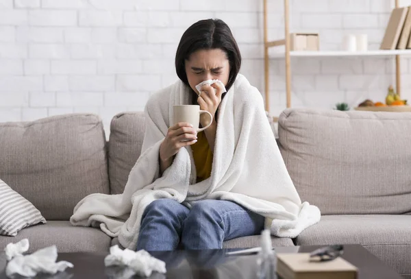 Epidemia choroby zakaźnej. Chora dziewczyna z ciepłym napojem cierpiąca na wirusa w domu — Zdjęcie stockowe