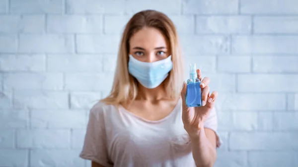Коронавирус не пройдет. Женщина в маске держит антисептик — стоковое фото