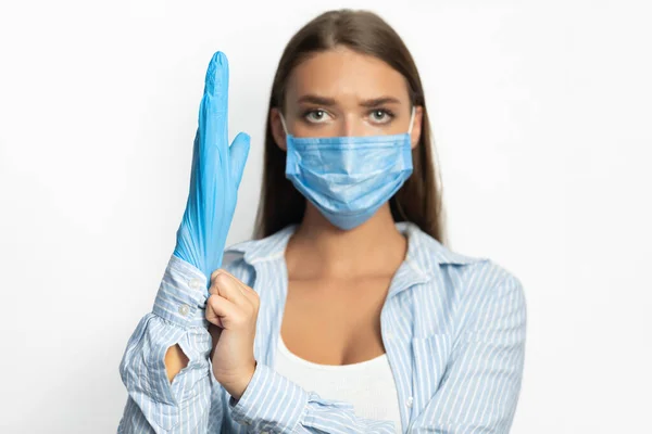 Vrouw dragen beschermende handschoenen en gezicht masker op witte achtergrond — Stockfoto