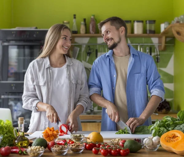 Attraktiv ung par matlagning grönsakssallad tillsammans i köket — Stockfoto