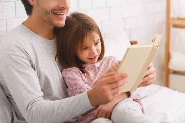 Close up of preschool girl reading book with father — Stock Photo, Image