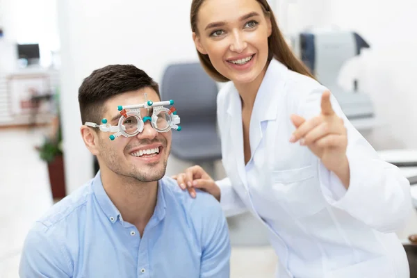 Optometrist überprüft das Sehvermögen der Patienten mit Versuchsrahmen — Stockfoto