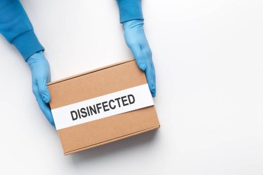 Karton dezenfekte edilmiş plastik eldivenler taşıyan teslimatçı.