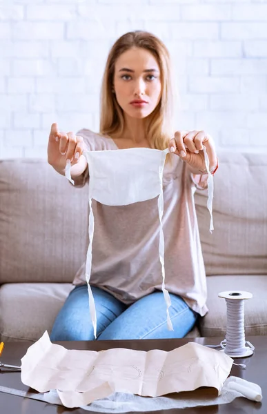 Quarantine 2019-ncov. Girl shows finished homemade mask — Stock Photo, Image