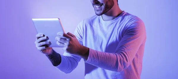 Man in neon dengan tablet di tangan — Stok Foto