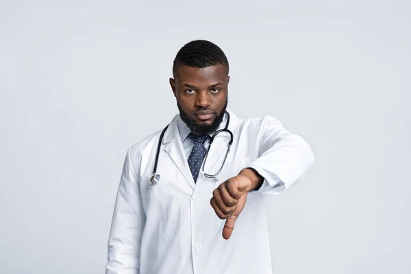 Kızgın genç siyahi doktor baş parmağını kaldırıyor. — Stok fotoğraf