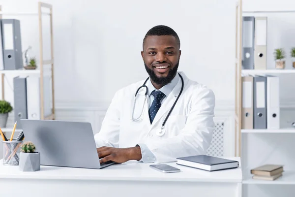 Foto de sonriente médico afroamericano trabajando en clínica —  Fotos de Stock