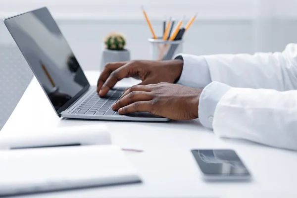 Afrikaanse arts handen werken met laptop, kantoor interieur — Stockfoto