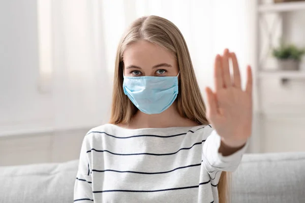 Young woman in medical protective mask gesturing stop — Stock Photo, Image