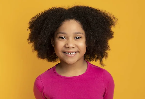 Positief schattig zwart kind, klein meisje, poseren bij de camera en glimlachen — Stockfoto