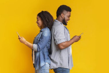 Siyah çift akıllı telefonlar kullanıyor, sırt sırta verip birbirlerini görmezden geliyorlar.