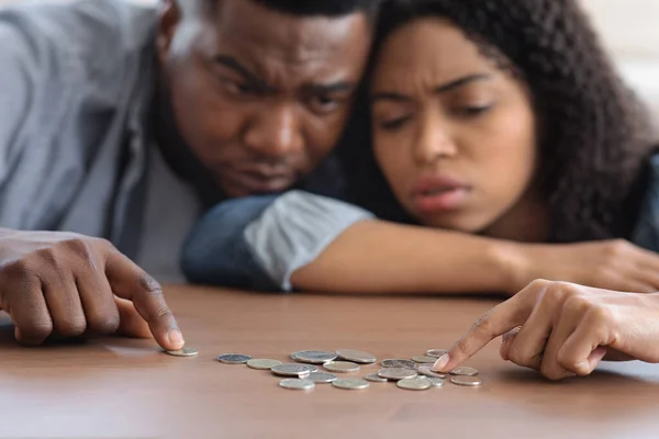 Problemas financeiros familiares. Casal negro contando moedas restantes, sofrendo de pobreza — Fotografia de Stock