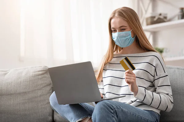 Young woman in protective mask buying goods online — Stock Photo, Image