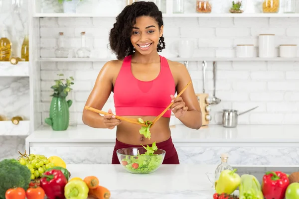 Vacker ung afro flicka förbereder grönsakssallad — Stockfoto