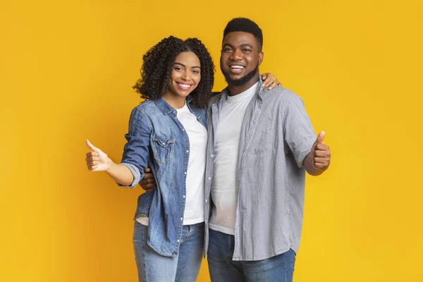Great choice. Happy african american couple gesturing thumbs up, recommending something — Stock Photo, Image